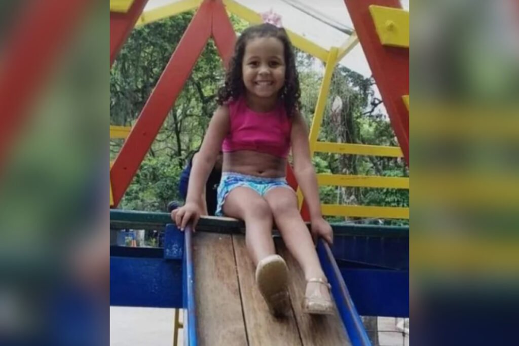 Menina Ana Clara sorrindo em um escorregador